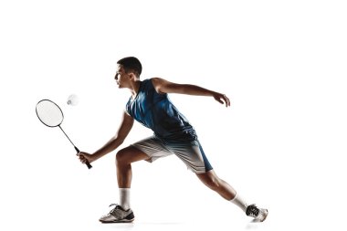 Küçük çocuk badminton oynarken beyaz stüdyo arka plan izole