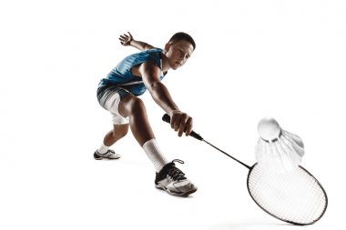Küçük çocuk badminton oynarken beyaz stüdyo arka plan izole