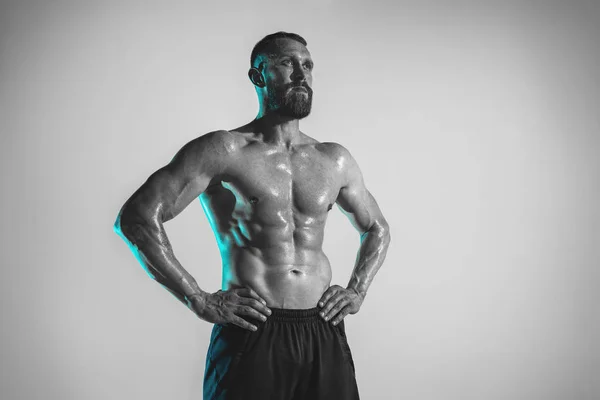 Young caucasian bodybuilder training over studio background — Stock Photo, Image