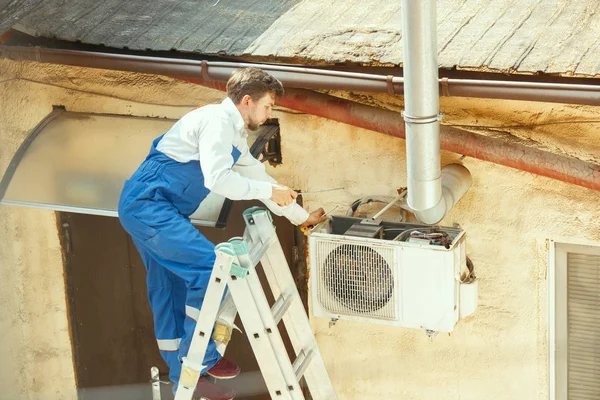 Técnico de AVAC trabalhando em uma parte do capacitor para unidade de condensação — Fotografia de Stock