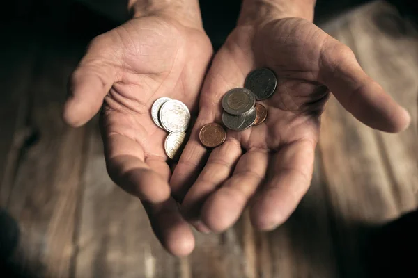 Masculino mendigo manos buscando dinero en el suelo de madera en camino público — Foto de Stock