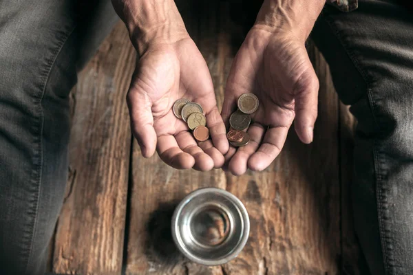 Mężczyzna żebrak ręce szuka pieniędzy na drewnianej podłodze w drodze publicznej drogi — Zdjęcie stockowe