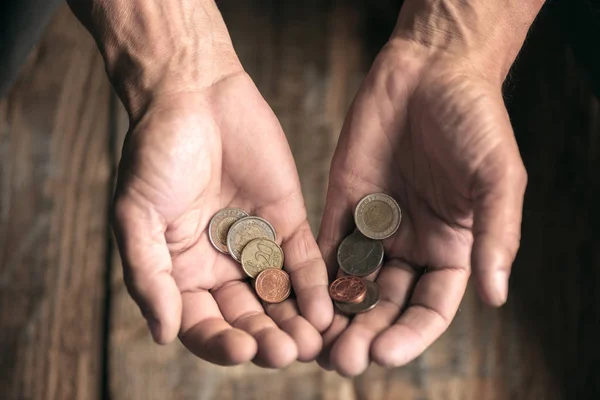 Mãos de mendigo masculino buscando dinheiro no chão de madeira no caminho público — Fotografia de Stock