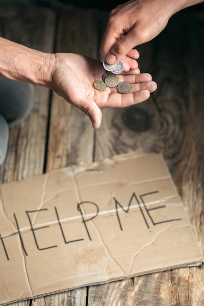 Masculino mendigo manos buscando dinero en el suelo de madera en camino público — Foto de Stock