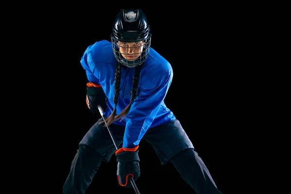 Young female hockey player with the stick isolated on black background — Stock Photo, Image