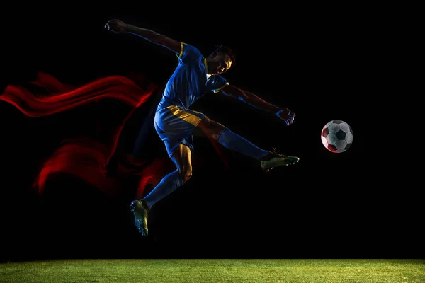 Kopeček mužské fotbalové hry na tmavém pozadí ve smíšeném světle — Stock fotografie