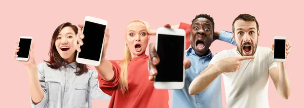 Retrato de pessoas mostrando tela de telefone celular isolado sobre fundo coral — Fotografia de Stock