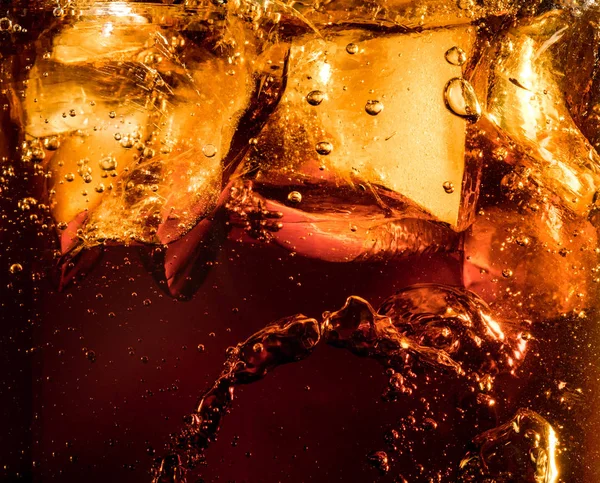 Nahaufnahme der Eiswürfel vor dunklem Cola-Hintergrund — Stockfoto