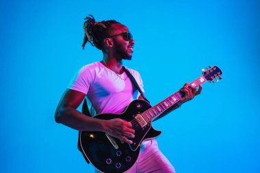 Genç Afro-Amerikan caz müzisyeni gitar çalıyor.