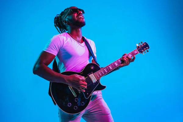 Young african-american jazz musician playing the guitar