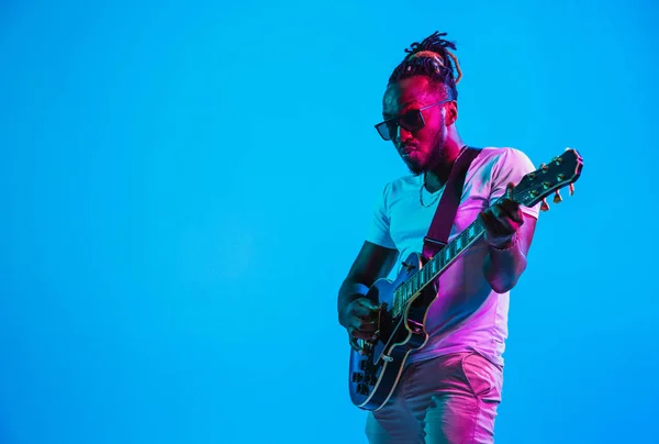 Young african-american jazz musician playing the guitar