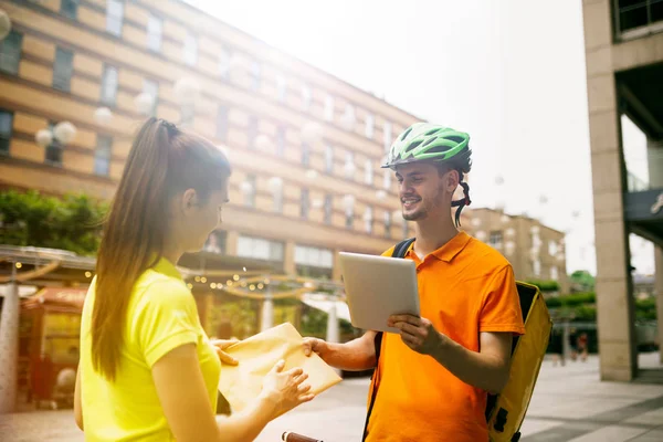 Jeune homme comme un messager livraison paquet à l'aide de gadgets — Photo