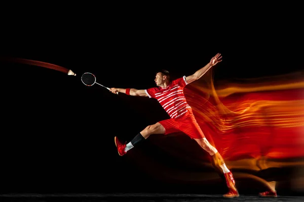 Giovane uomo giocare badminton isolato su sfondo nero studio — Foto Stock