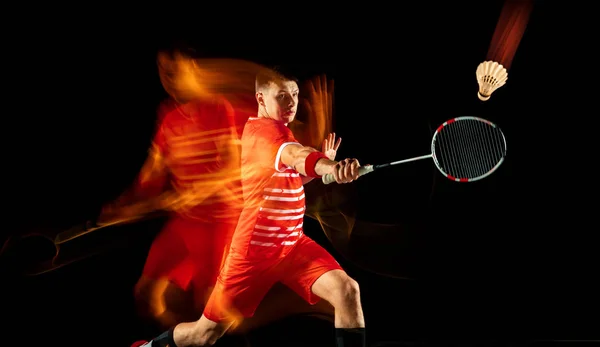 Ung man spelar badminton isolerad på svart studio bakgrund — Stockfoto