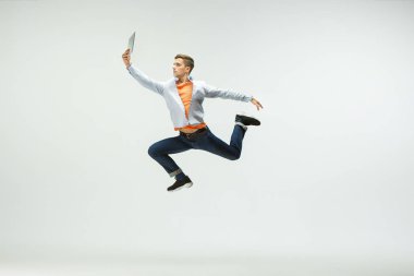 Adam ofiste çalışan ve stüdyo arka plan üzerinde izole atlama