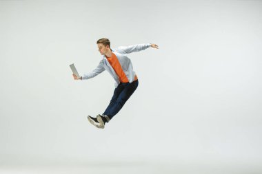 Adam ofiste çalışan ve stüdyo arka plan üzerinde izole atlama