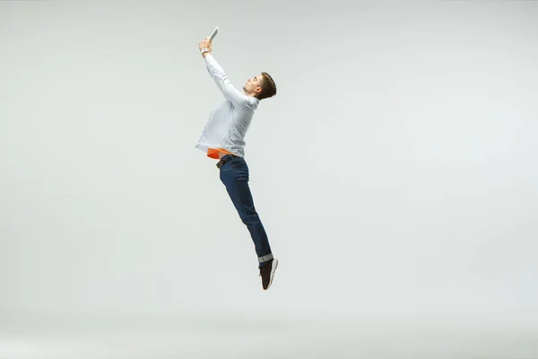 Homem trabalhando no escritório e pulando isolado no fundo do estúdio — Fotografia de Stock