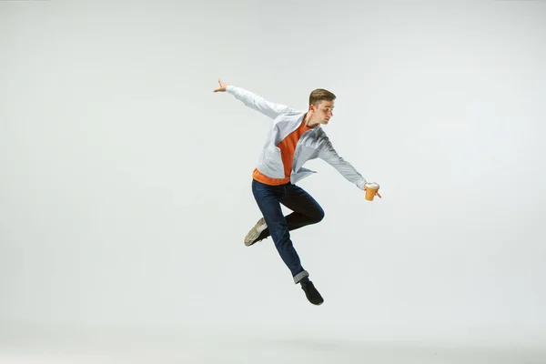 Homem trabalhando no escritório e pulando isolado no fundo do estúdio — Fotografia de Stock