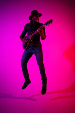Genç Afro-Amerikan caz müzisyeni gitar çalıyor.