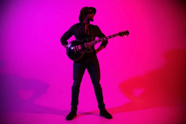 Genç Afro-Amerikan caz müzisyeni gitar çalıyor.