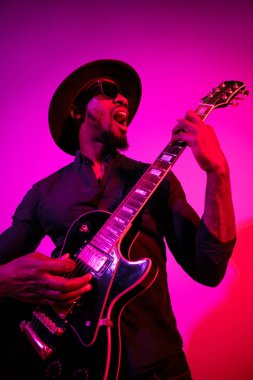 Genç Afro-Amerikan caz müzisyeni gitar çalıyor.