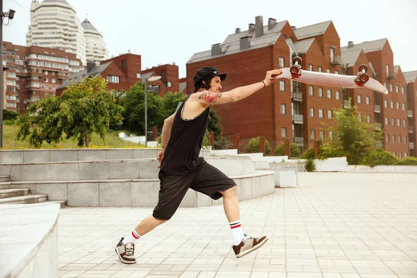 Skateboarder fazendo um truque na rua citys em dia nublado — Fotografia de Stock