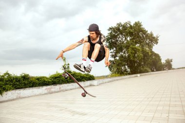 Kaykaycı bulutlu bir günde citys sokakta bir hile yapıyor