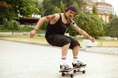 Kaykaycı bulutlu bir günde citys sokakta bir hile yapıyor