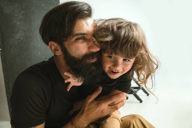 Baba oturma odasında genç oğlu ile oynuyor