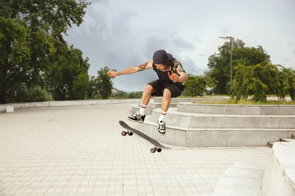 Skateboarder haciendo un truco en la calle citys en día nublado — Foto de Stock