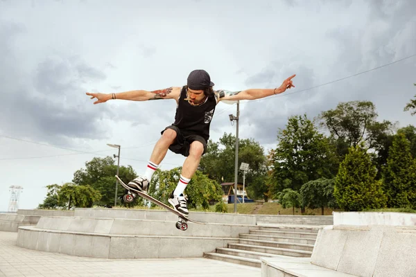 Skateboarder doing a trick at the citys street in cloudly day