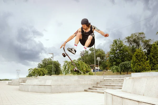 Skateboarder doet een truc in de vewijderd Street in cloudly Day — Stockfoto