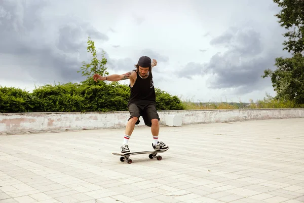 Skateboarder doet een truc in de vewijderd Street in cloudly Day — Stockfoto