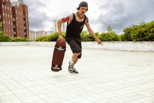 Skateboarder robi sztuczkę na ulicy miejskich w zachmurzenie dzień — Zdjęcie stockowe