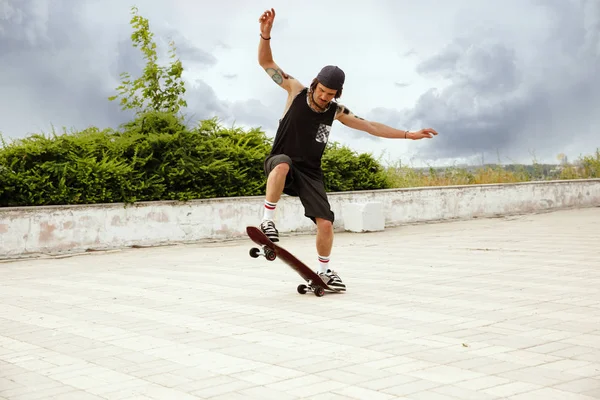 Skateboarder haciendo un truco en la calle citys en día nublado — Foto de Stock