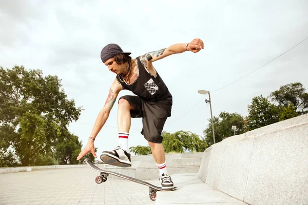 Skateboarder robi sztuczkę na ulicy miejskich w zachmurzenie dzień — Zdjęcie stockowe