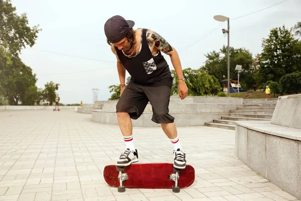 Skateboarder doing a trick at the citys street in cloudly day — Stock Photo, Image