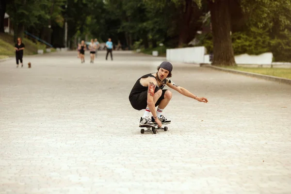 Skateboarder doing a trick at the citys street in cloudly day — Stock Photo, Image