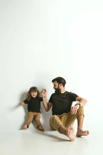 Otec si hrál s mladým synem na pozadí bílého studia — Stock fotografie