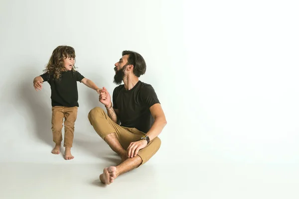 Padre giocare con giovane figlio contro bianco studio sfondo — Foto Stock