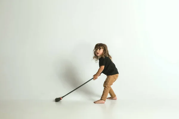 Criança sentada e brincando em poltrona no fundo do estúdio branco — Fotografia de Stock