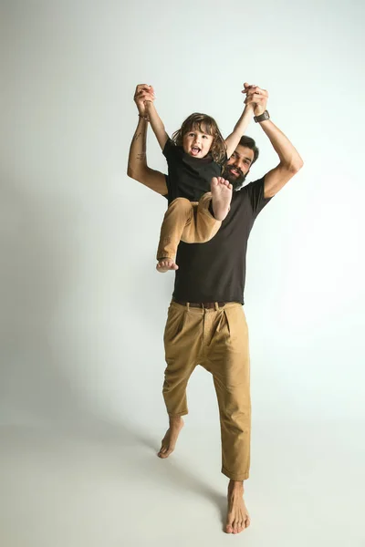 白いスタジオの背景に対して若い息子と遊ぶ父 — ストック写真