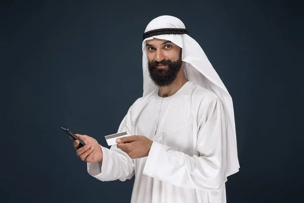 Árabe saudi homem no escuro azul estúdio fundo — Fotografia de Stock