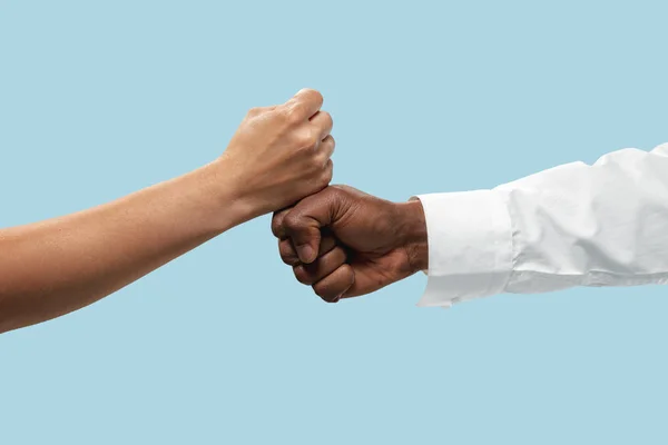 Two male hands competion in arm wrestling isolated on blue studio background — Stock Photo, Image