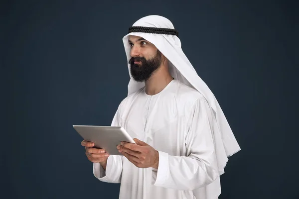 Арабский сауди бизнесмен на темно-синем фоне студии — стоковое фото