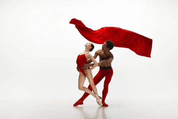 Joven pareja elegante de bailarines de ballet bailando sobre fondo blanco estudio — Foto de Stock