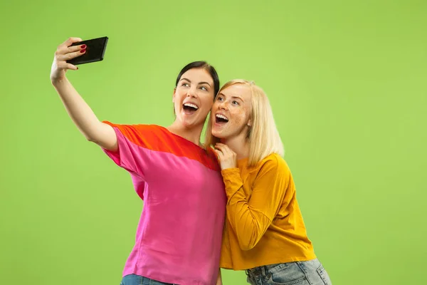 Portrait of pretty girls isolated on green studio background — Stock Photo, Image