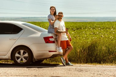 Güneşli bir günde arabada seyahat eden genç çift