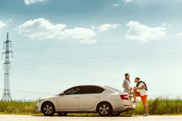 Casal jovem viajando no carro em dia ensolarado — Fotografia de Stock