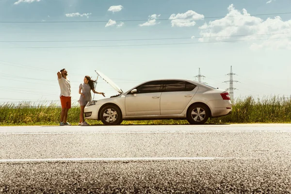 Pareja joven viajando en el coche en un día soleado — Foto de Stock